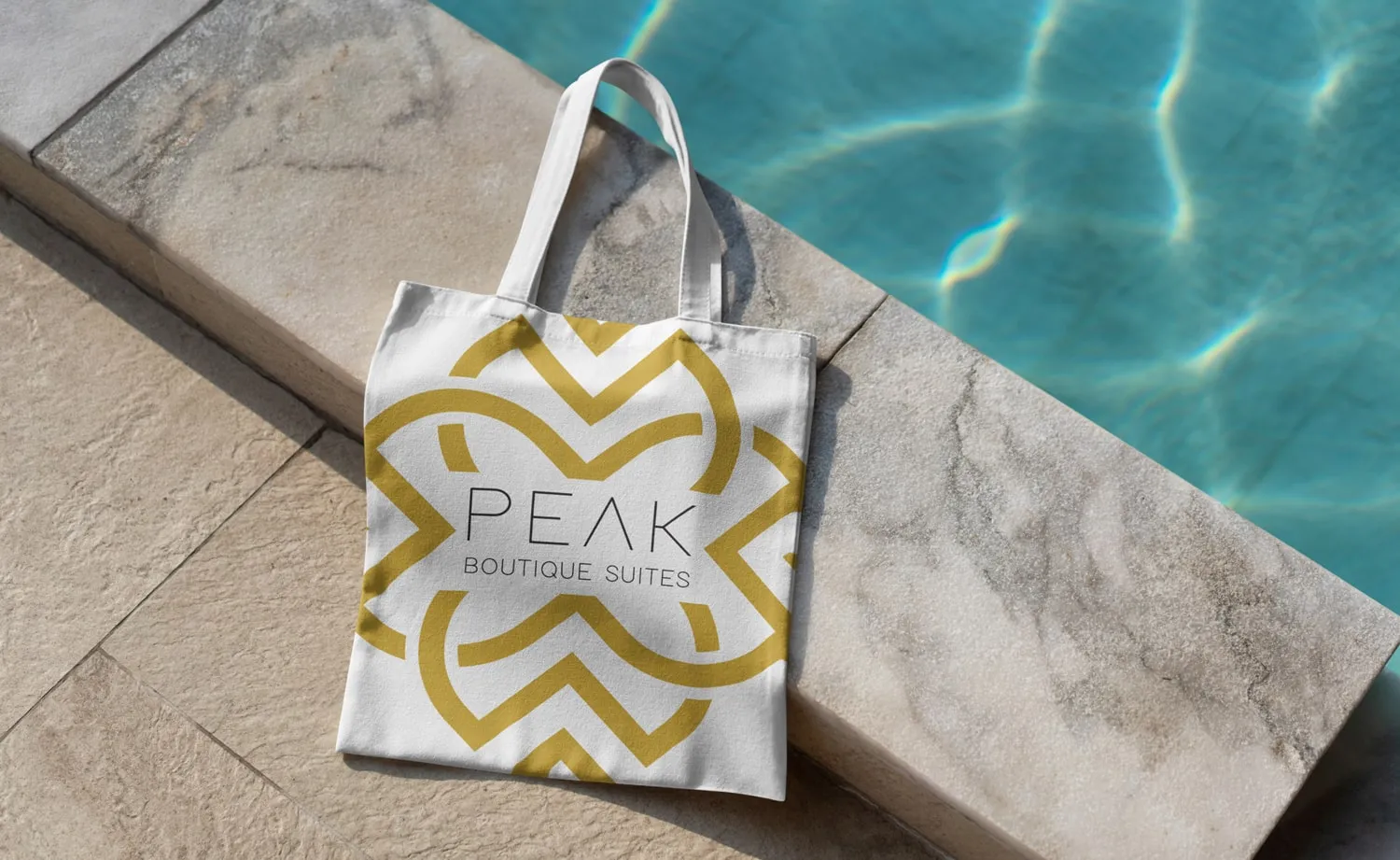 המיתוג של PEAK Boutique Suites: תיק בד עם הסמל ליד בריכה