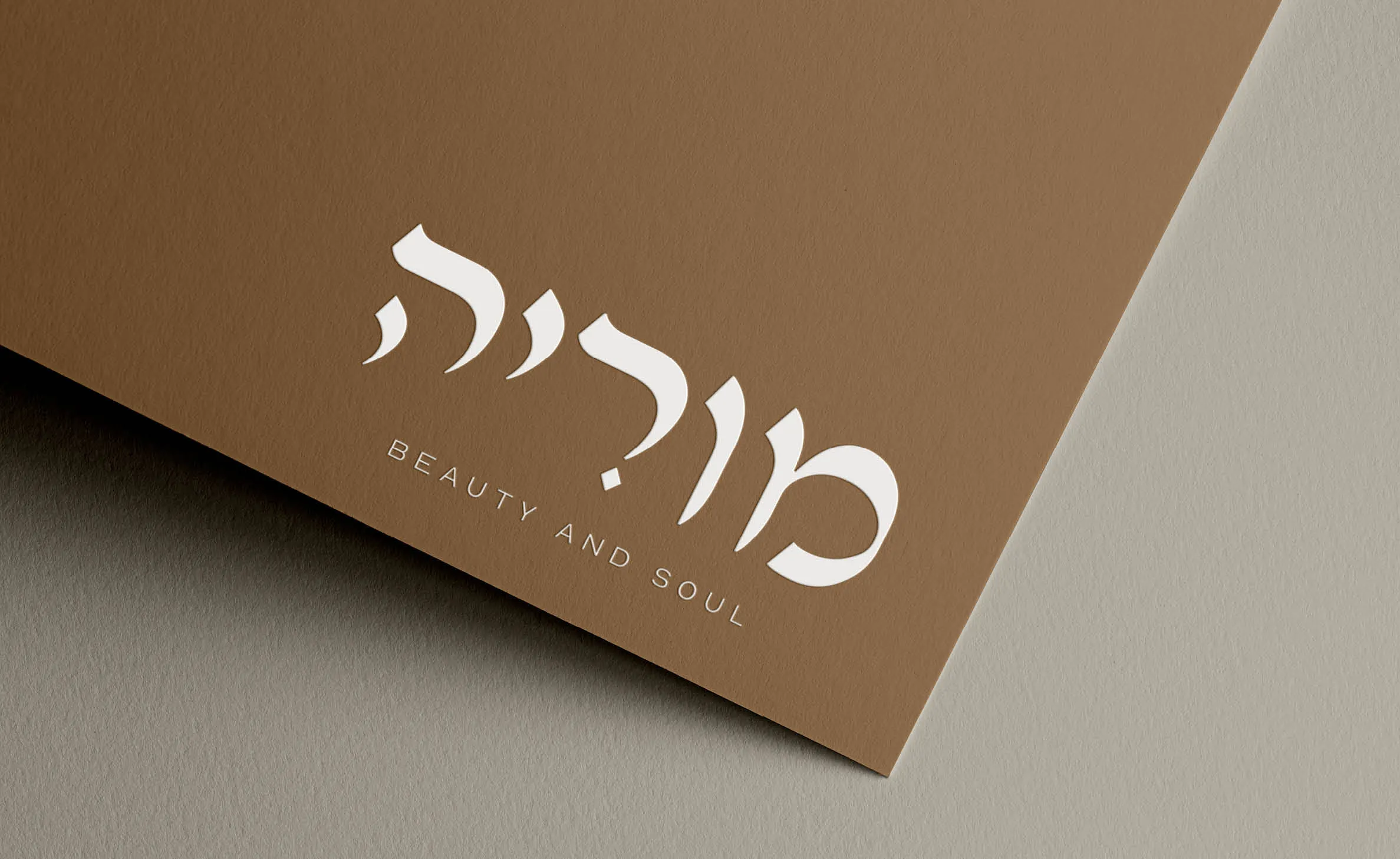 המיתוג של מוריה: הלוגו בלבן על נייר חום