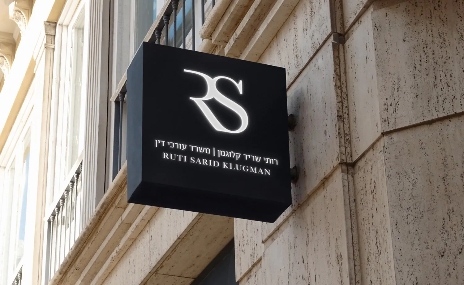 המיתוג של רותי שריד קלוגמן: שלט שחור ממותג על חזית בניין
